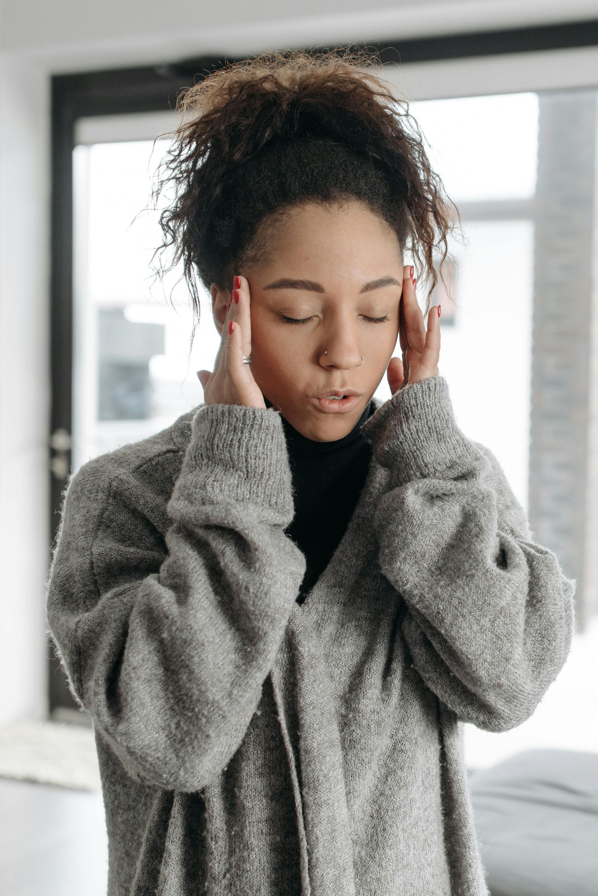 A woman is holding her head because she has a headache.