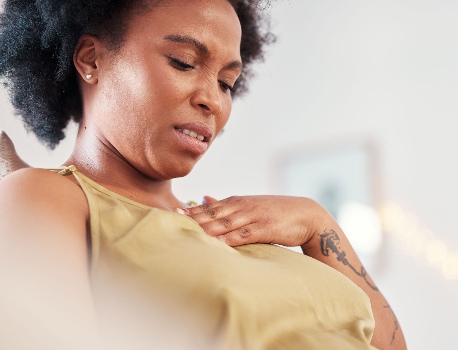 Worried young black woman suffering from acid reflux or heartburn