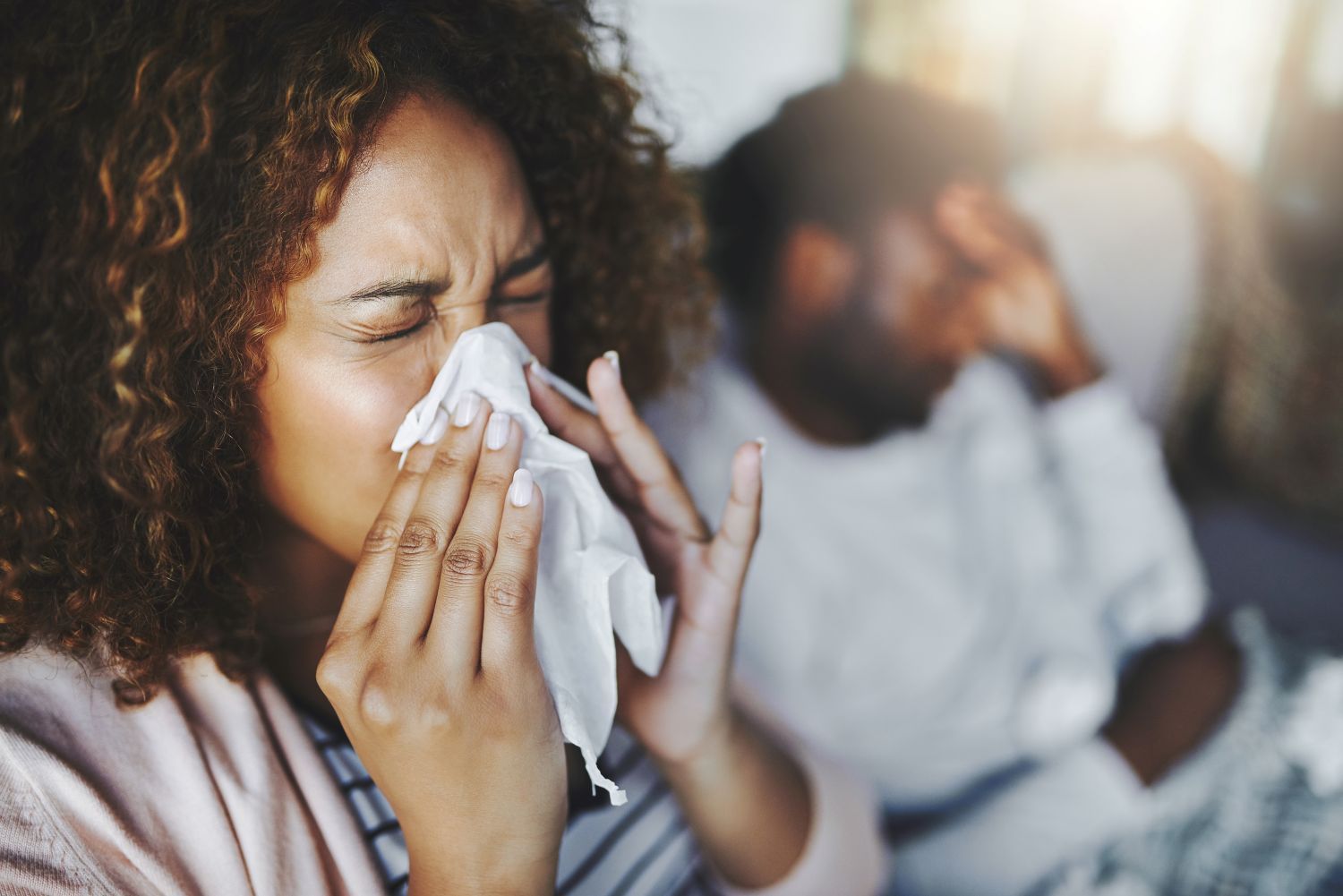 Woman keeps sneezing on a tissue