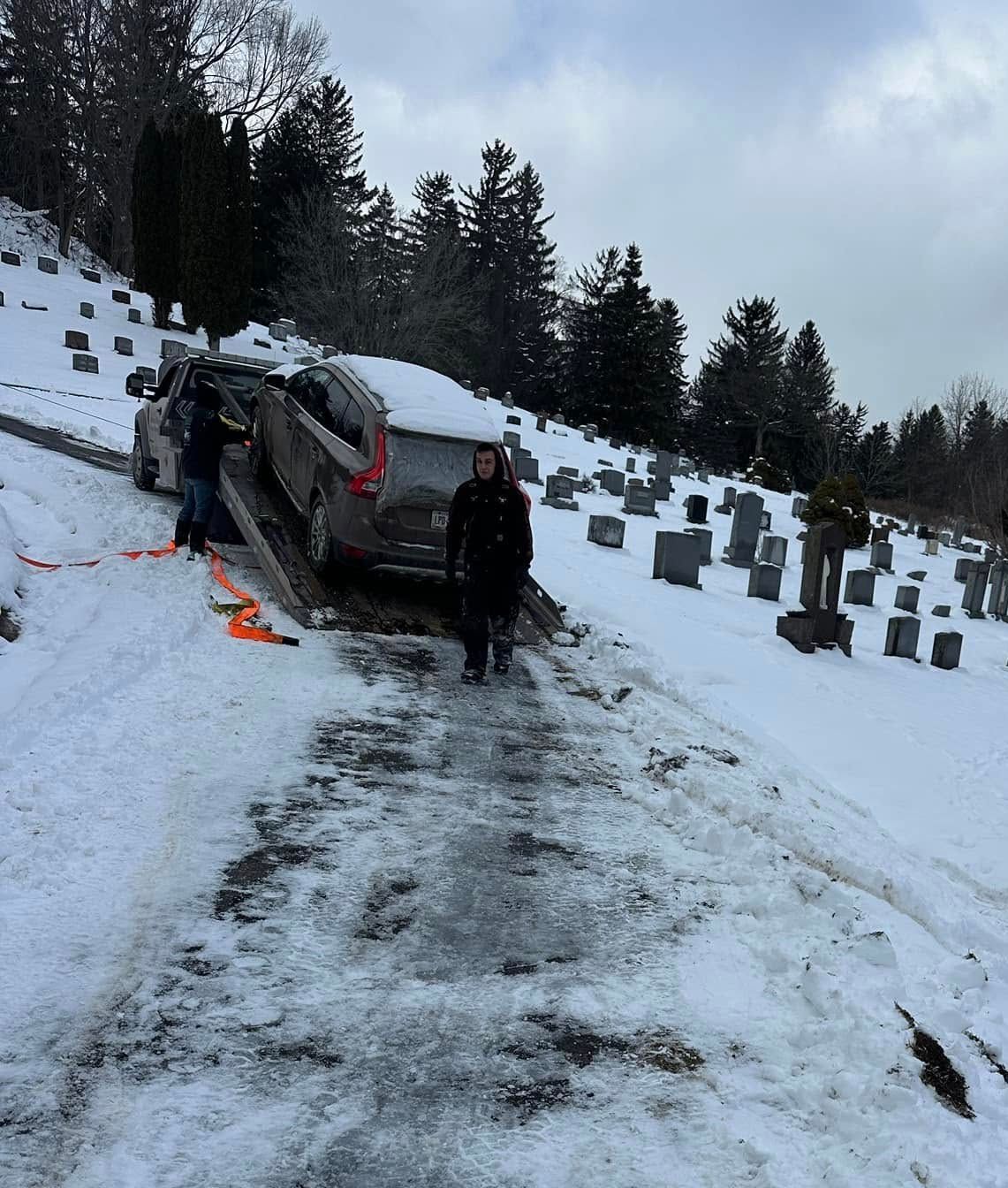 A car is stuck in the snow in a cemetery