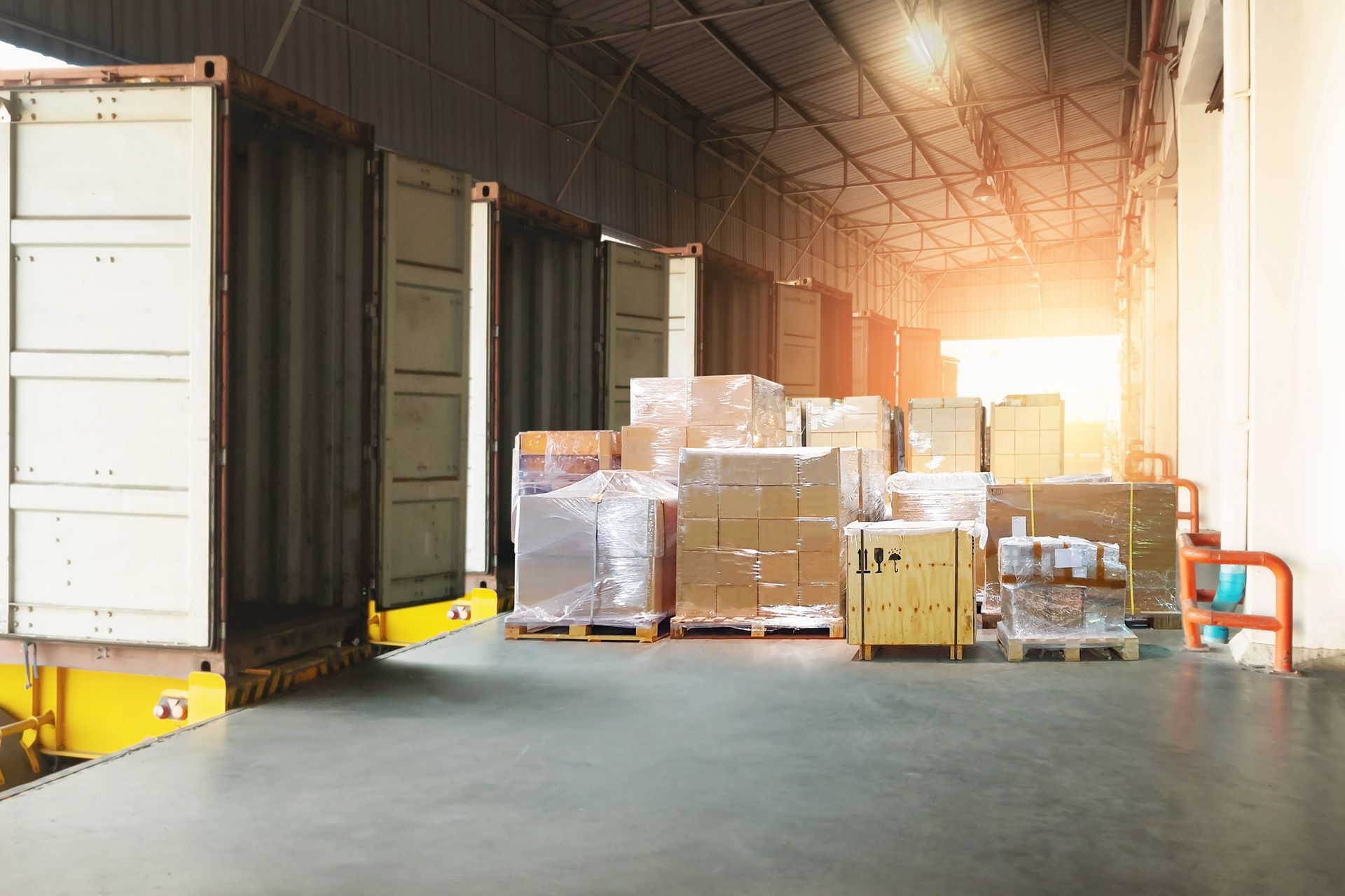 Container per la spedizione scaricati presso la banchina di carico di un magazzino, scatole su pallet.