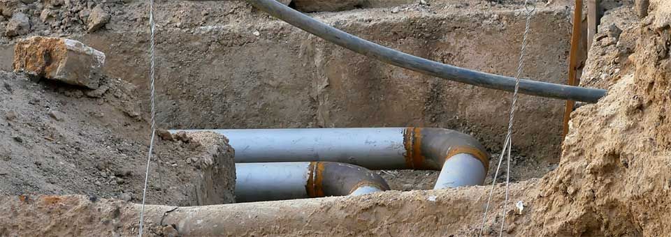 Vacuum truck excavation pit exposing pipes