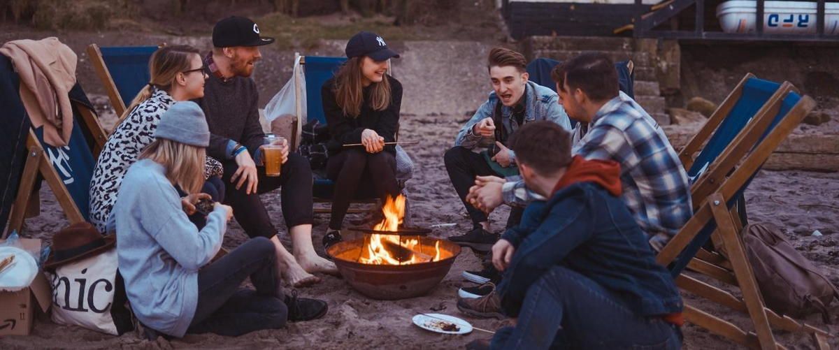 A group of people are sitting around a fire pit.