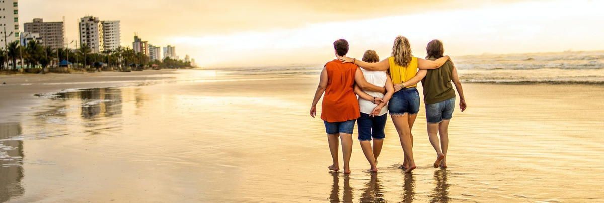 A group of women are walking on a beach.