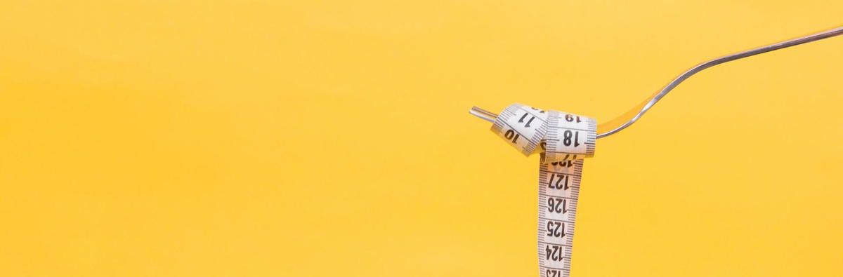 A measuring tape is tied to a fork on a yellow background.