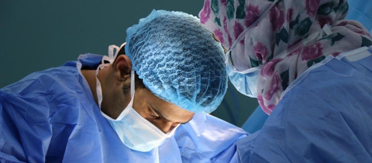 A surgeon is operating on a patient in an operating room.