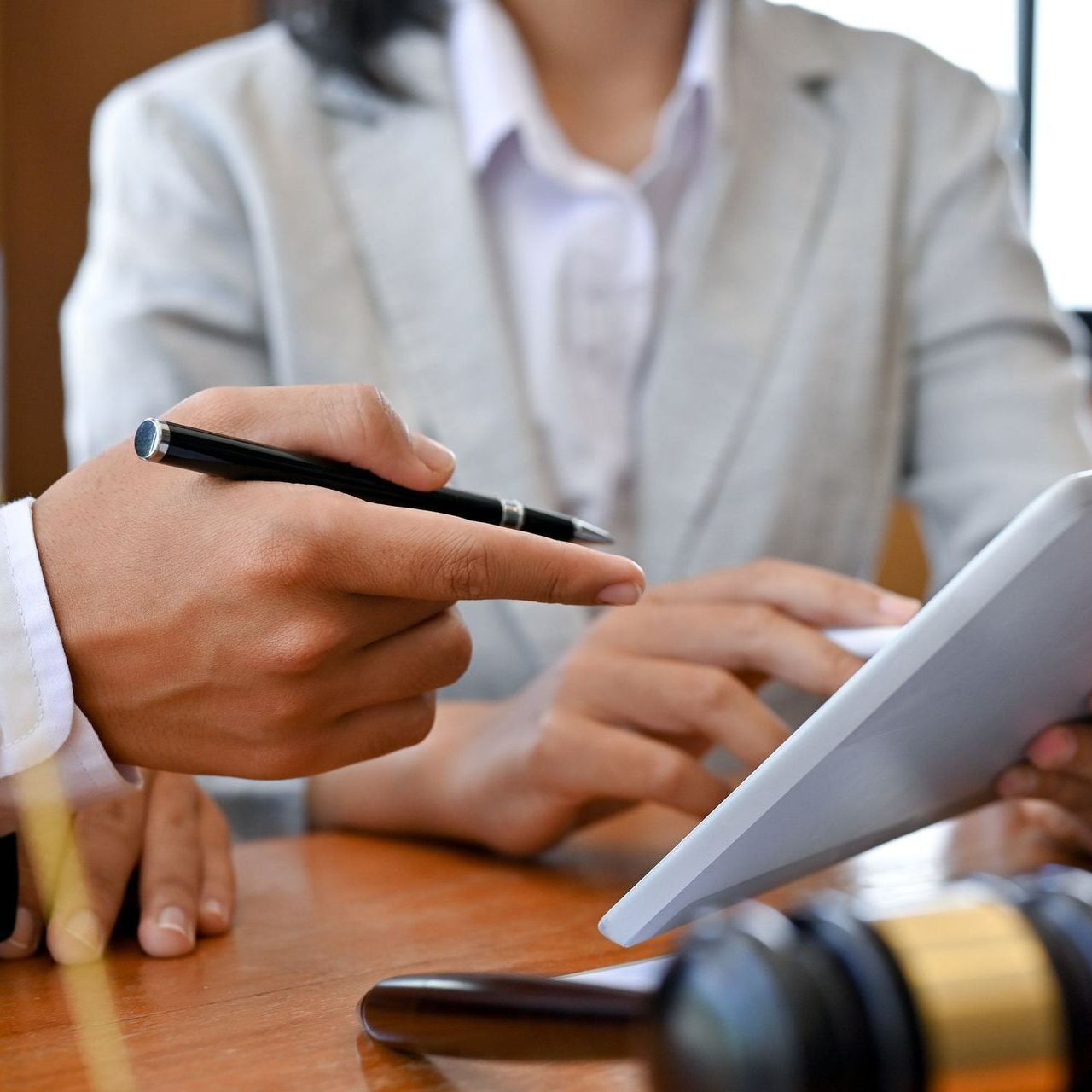 A man is pointing at a tablet while a woman looks on.