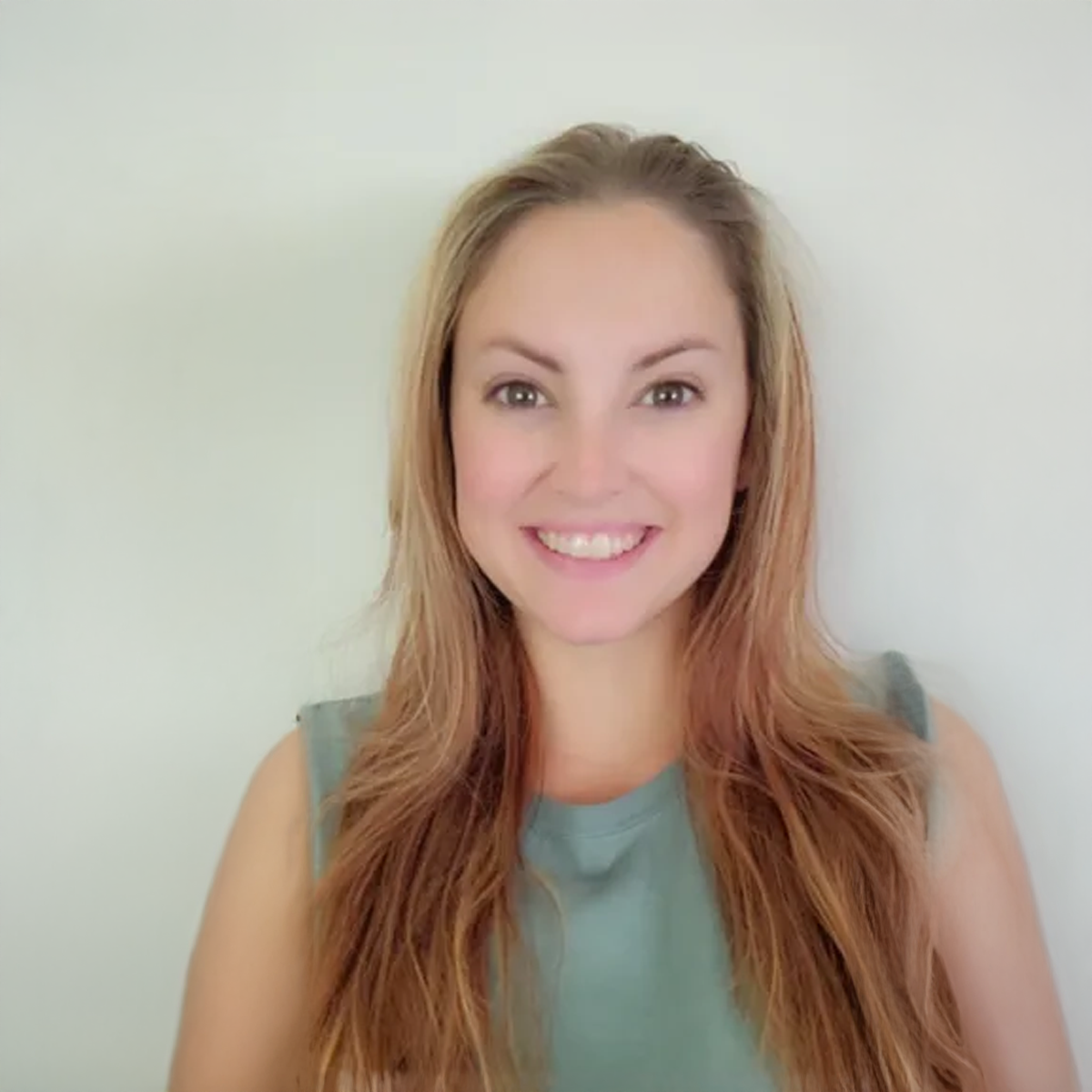 A woman with long hair is smiling for the camera.