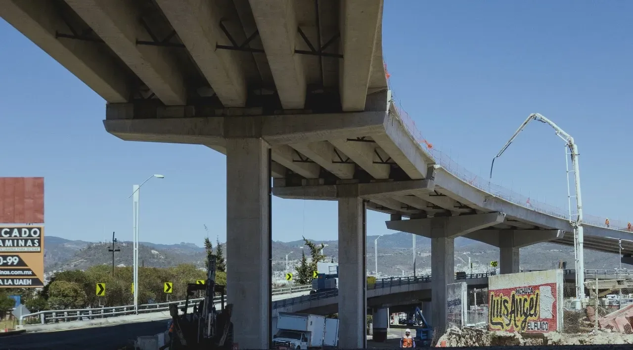 Curving concrete highway overpass against a blue sky with scattered clouds.