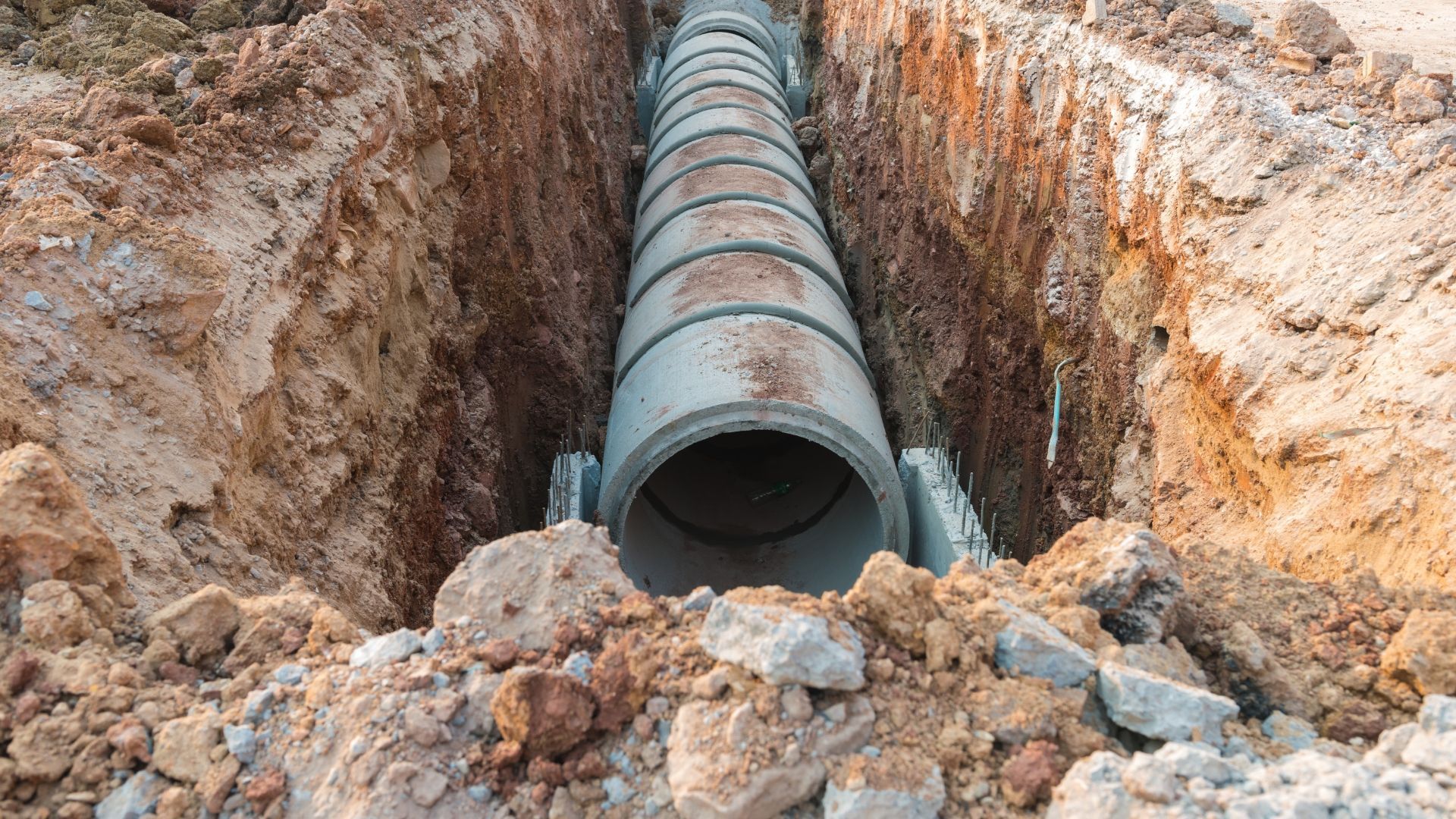 Concrete pipes laid in a trench, prepared for underground infrastructure.