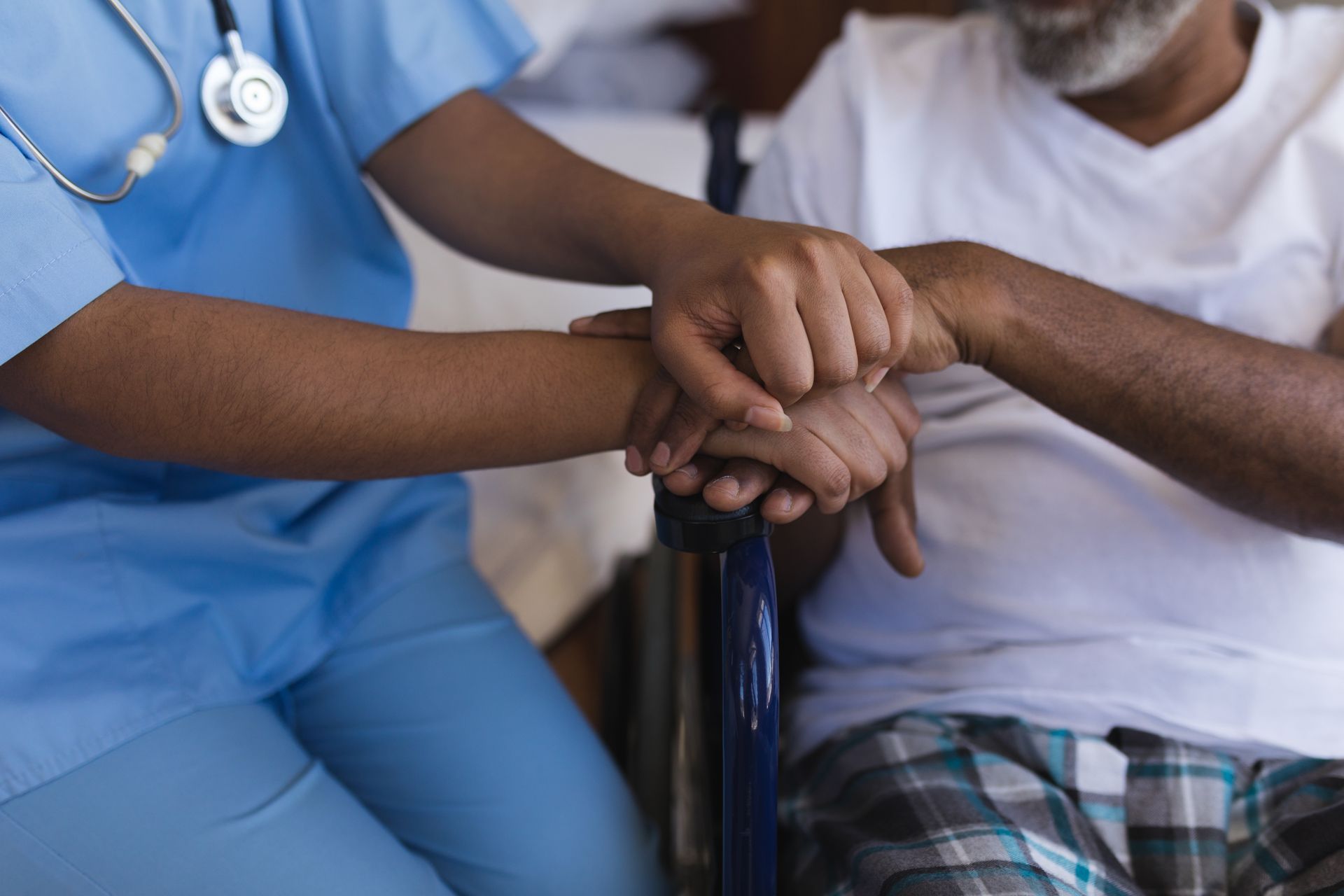 Closeup of caring nurse comforting senior patient
