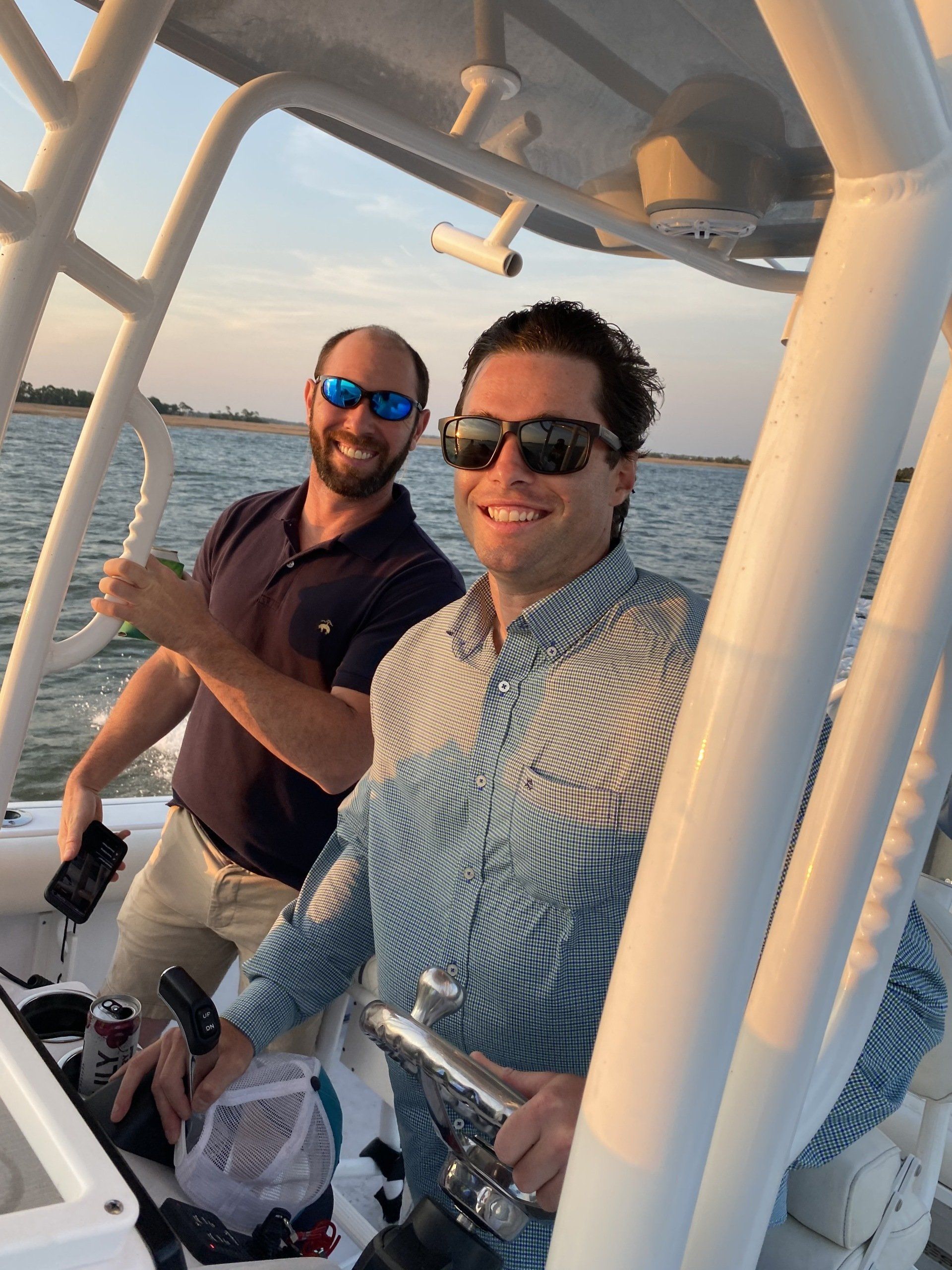 Two men wearing sunglasses are sitting on a boat