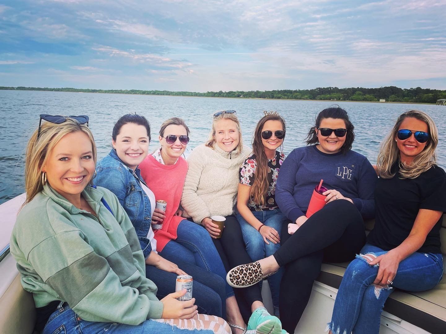 A group of women are sitting on a boat in the water.