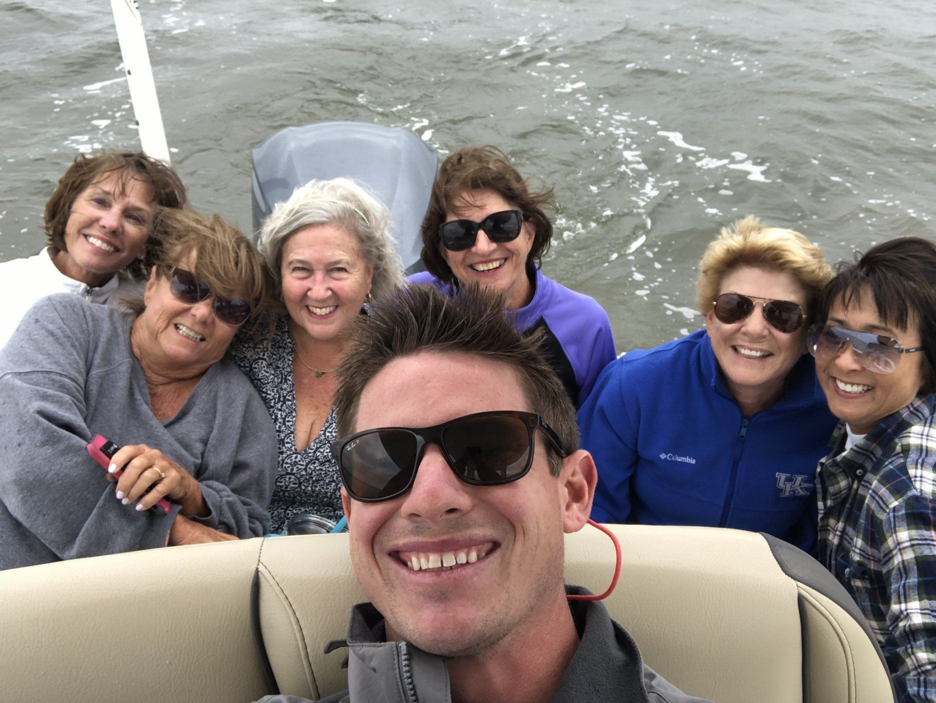 A group of people are taking a selfie on a boat.