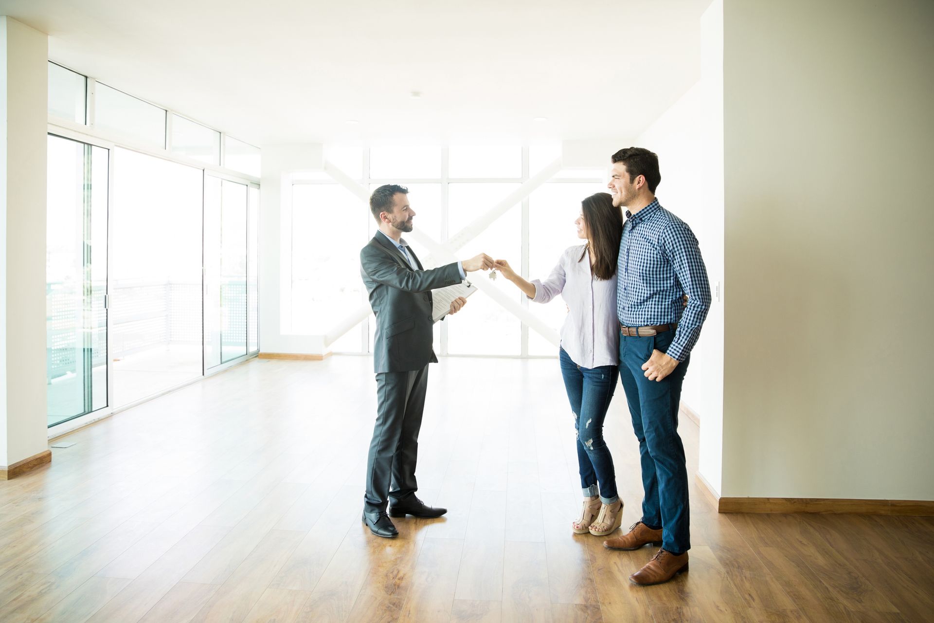 A man is shaking hands with a woman in an empty room.