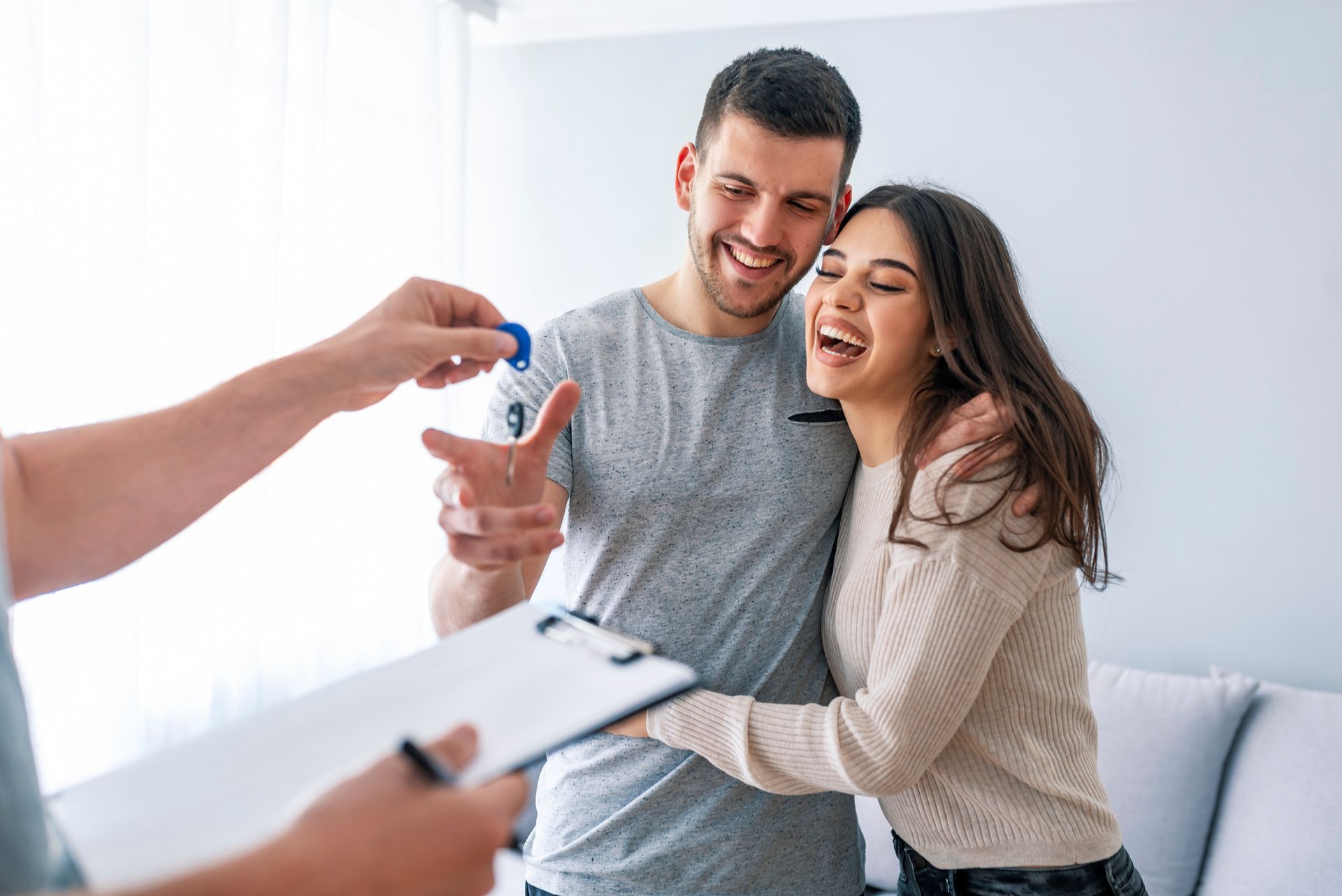 A man is giving a woman a set of keys to their new home.