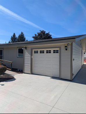 A house with a white garage door and a concrete driveway.