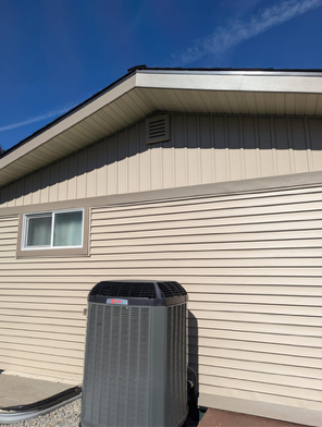 A house with a window and an air conditioner on the side