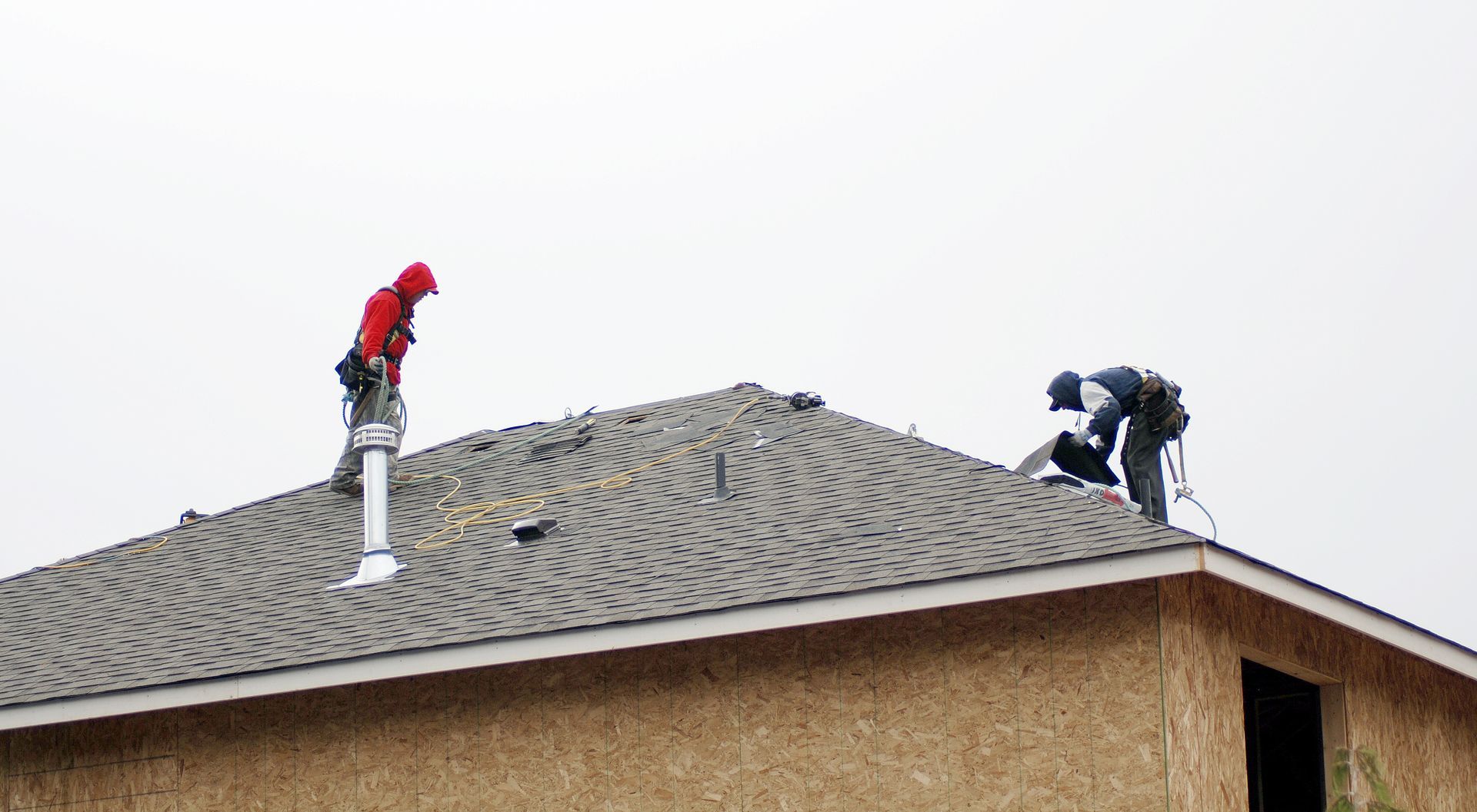 Expert roofers install protective shingles on a new residential construction project.