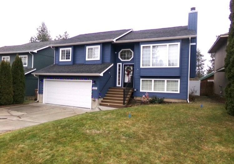 A large blue house with a white garage door