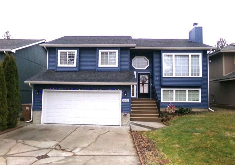 A large blue house with a white garage door