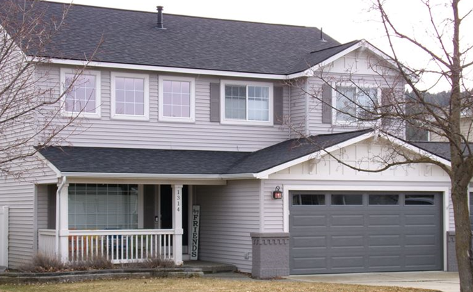 A house with a gray garage door and a porch