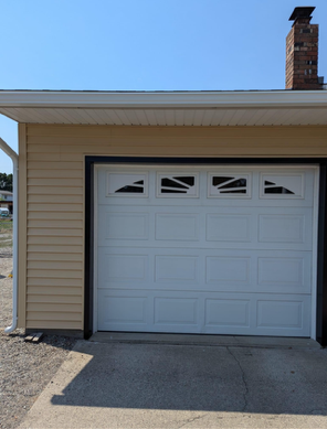 A white garage door with a chimney on top of it