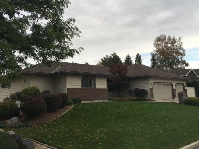 A house with a brown roof and a large lawn