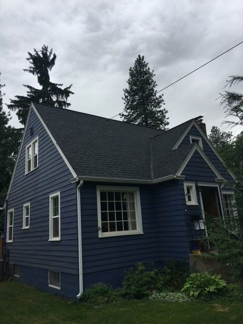 A blue house with a black roof and white trim
