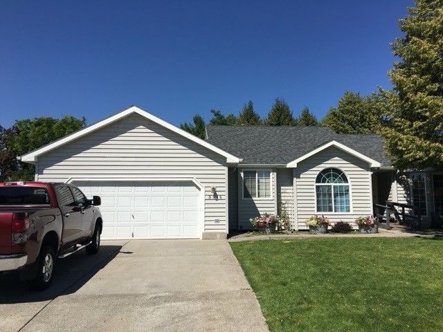 A red truck is parked in front of a house
