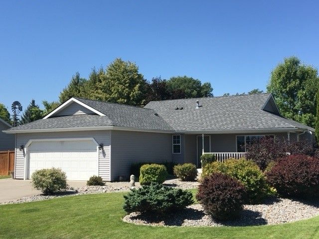 A house with a gray roof and a white garage door