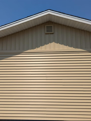 A close up of a tan garage door with a white roof.