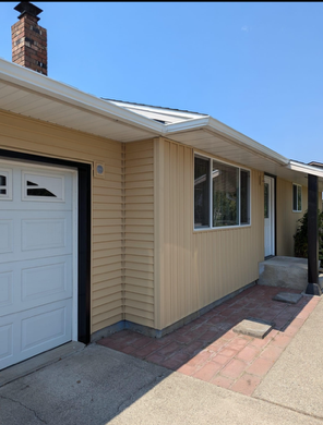 A house with a white garage door and a chimney