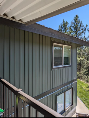 A view of a house from a balcony with trees in the background