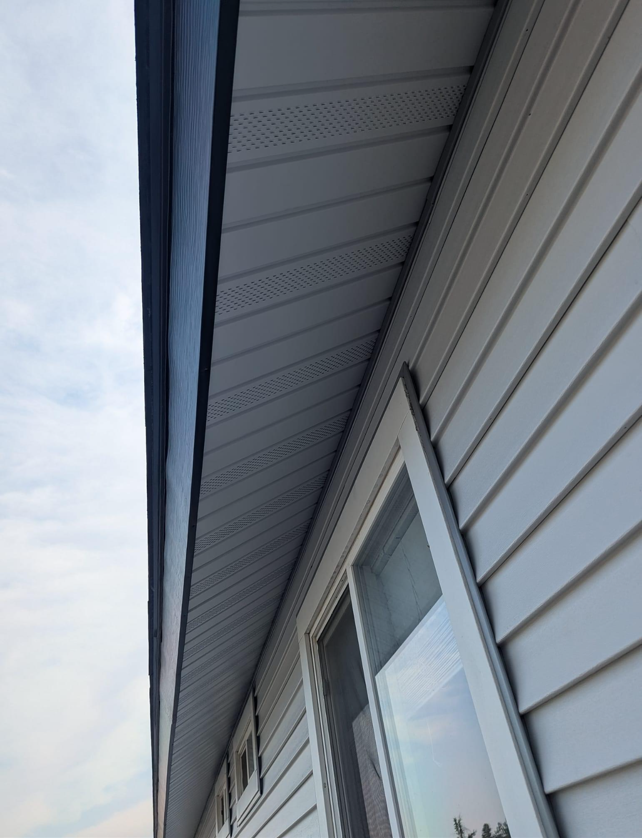 Looking up at the roof of a house with a window.