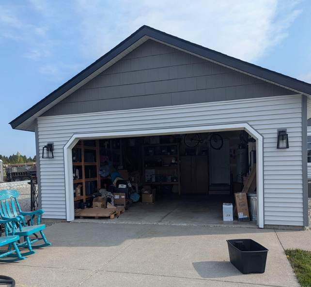 A garage with the door open and a rocking chair in front of it