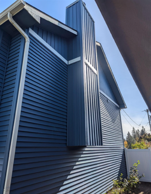 A blue house with a chimney on the side of it