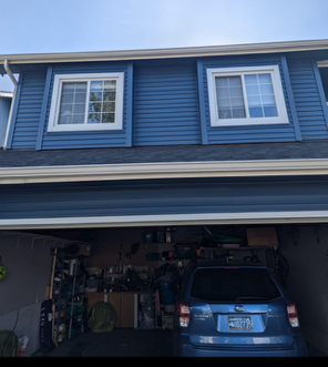 A blue car is parked in the garage of a house