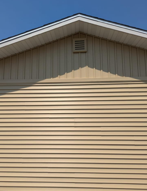 A close up of a tan house with a white roof.