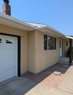 A house with a white garage door and a chimney
