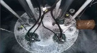 A close up of a dirty drain with a bunch of wires coming out of it.