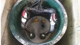 A manhole cover with a bunch of wires coming out of it.