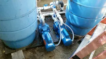 A sump pump is sitting in a hole in the ground.