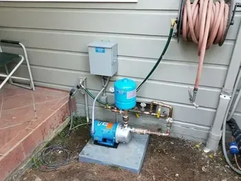 A manhole cover with pipes coming out of it and a blue hose coming out of it.