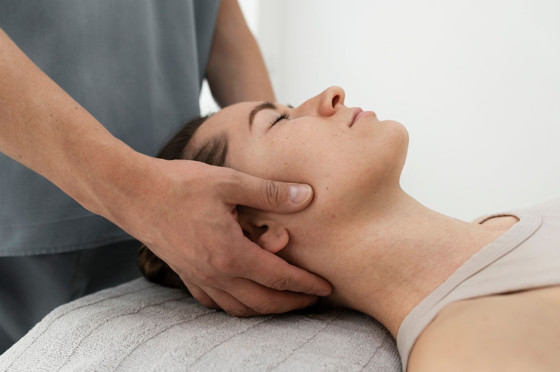 A woman is getting a head massage from a man.