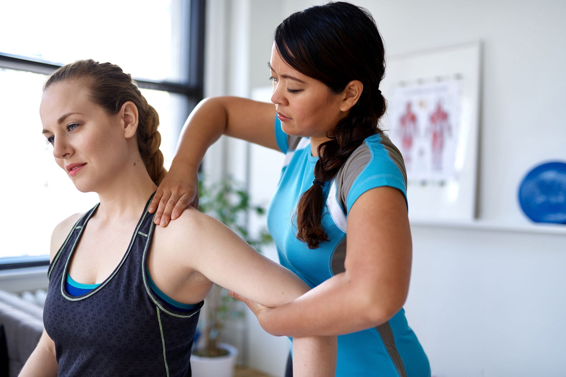 A woman is getting a massage from a female physical therapist.