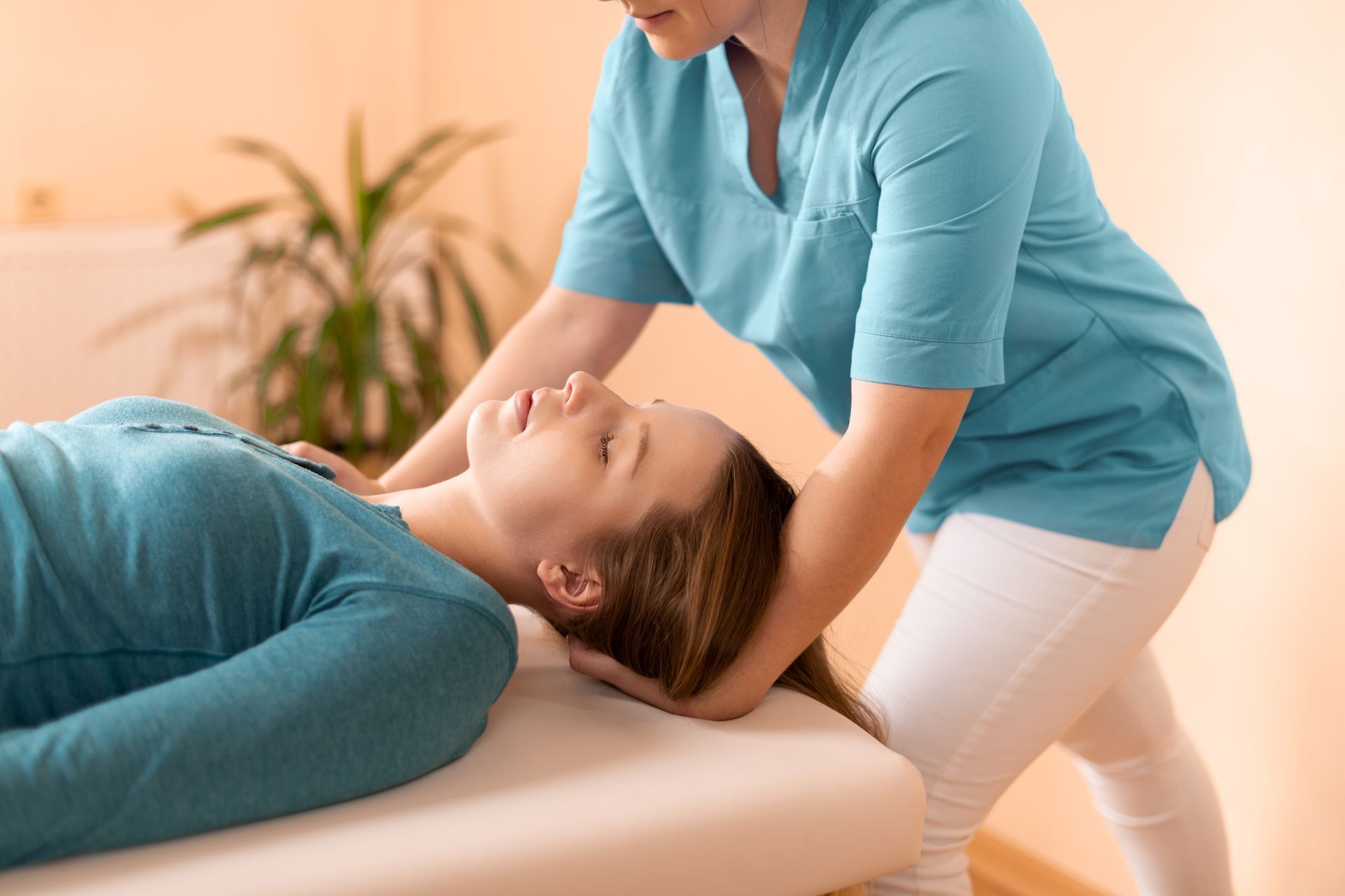 A woman is laying on a table getting a massage from a doctor.