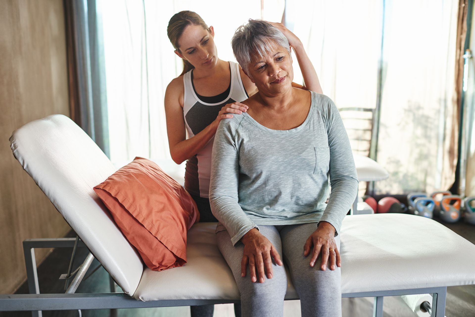 A woman is giving an older woman a massage on a massage table.