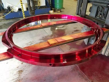 A red metal ring is sitting on top of a wooden table.