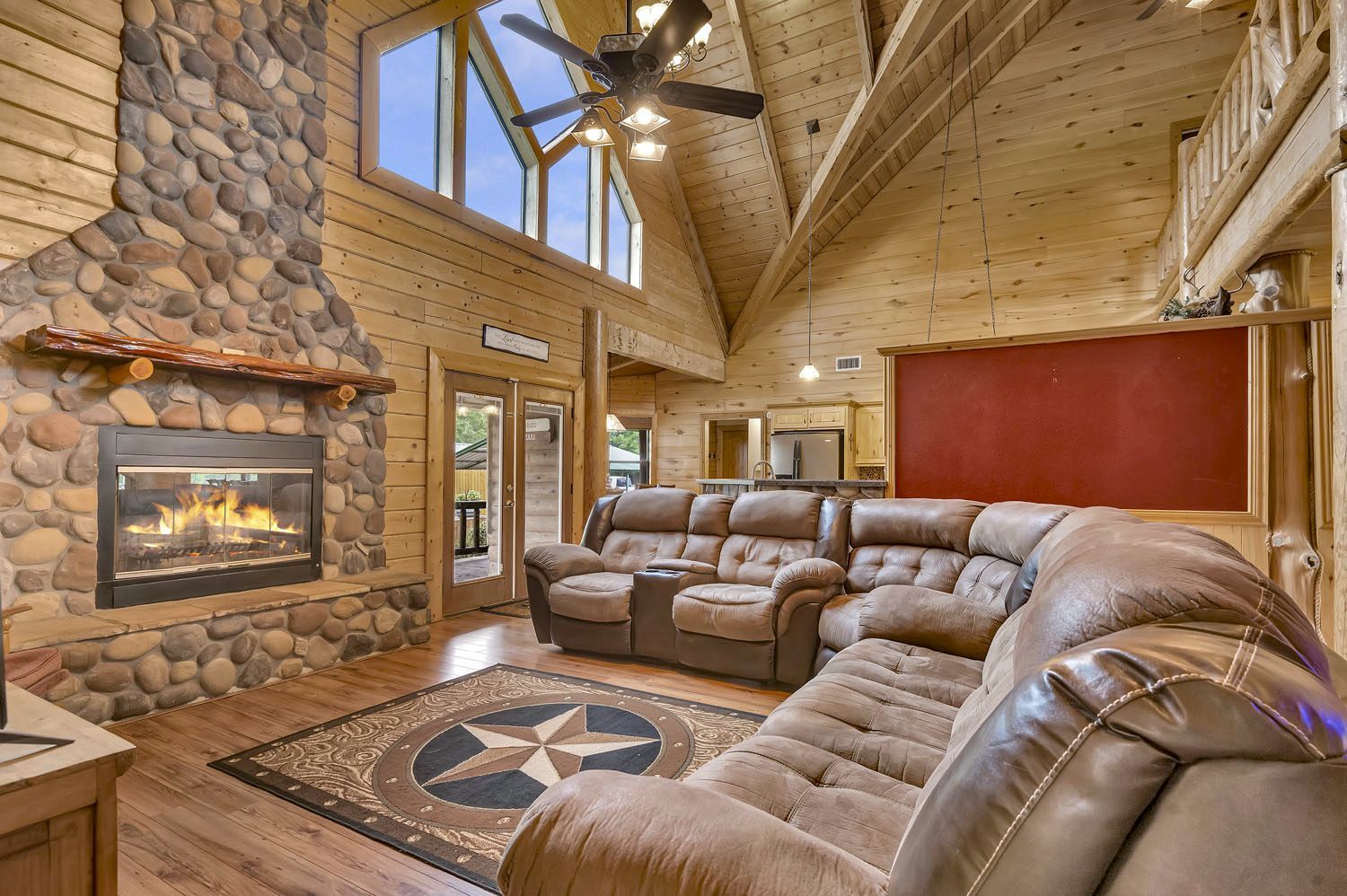 A living room in a log cabin with a fireplace and a couch.